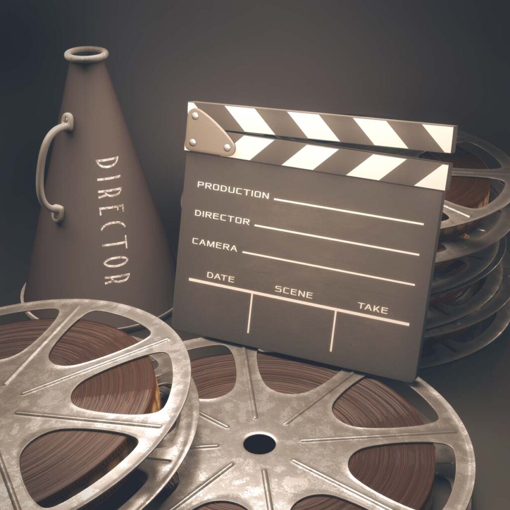 Clap board, and cinema reels aranged artistically with directors cone